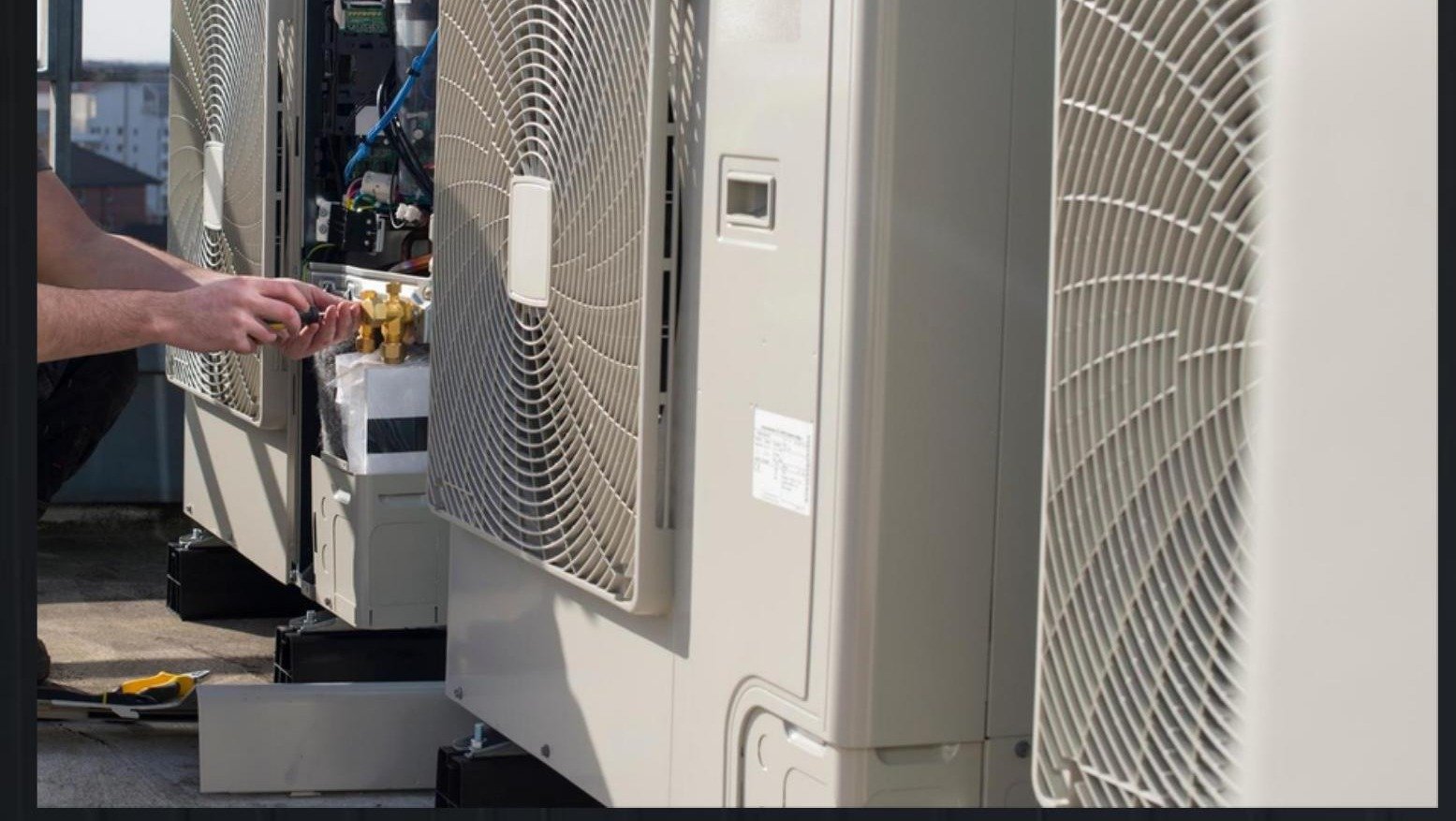 Technician installing a commercial air conditioning condenser unit